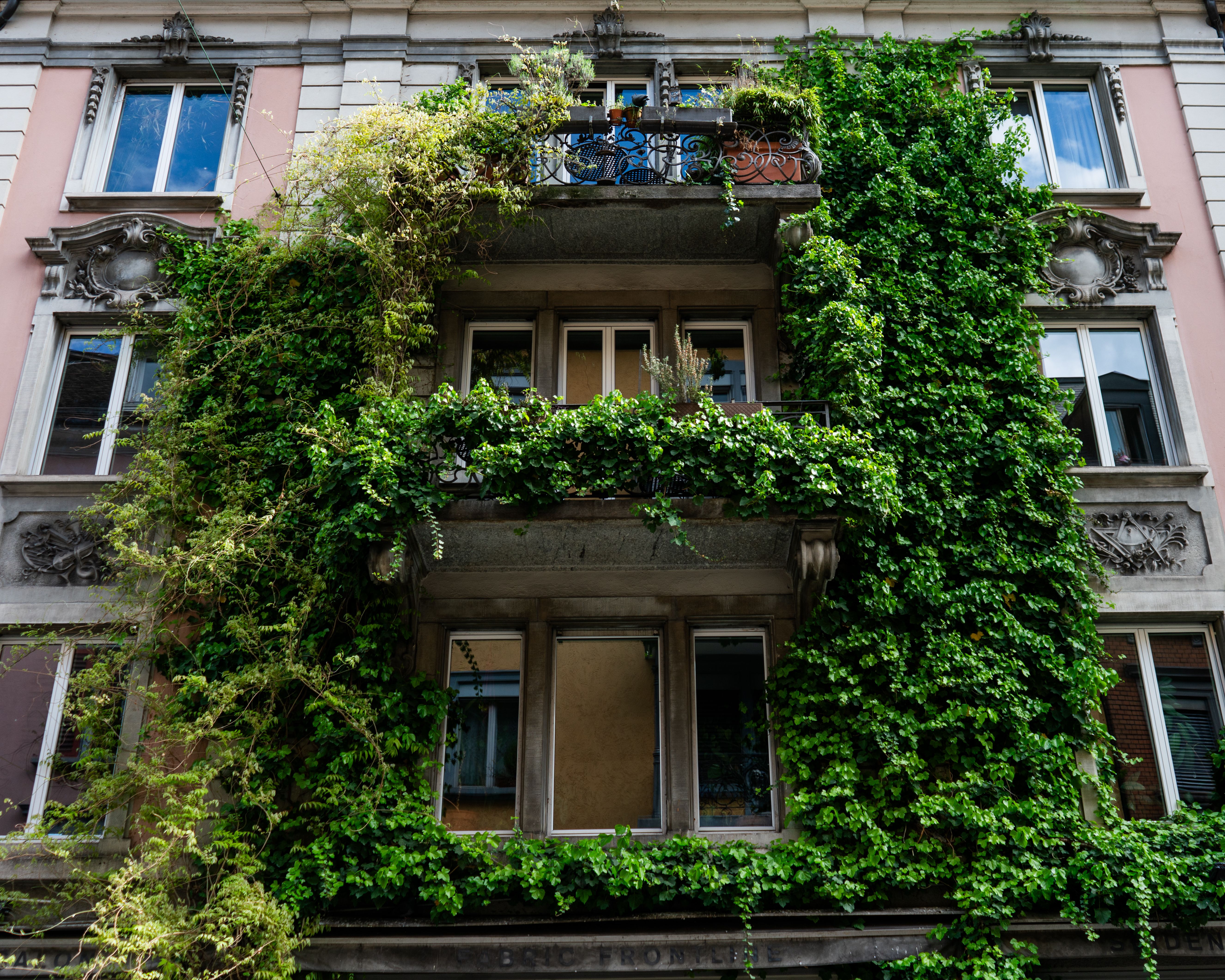 Balcone con fioritura abbondante rossa e rosa lungo la ringhiera